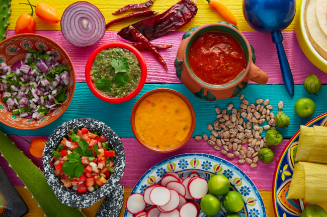 Mexican food display with sauces, nopal, tamale, agave, and guacamole