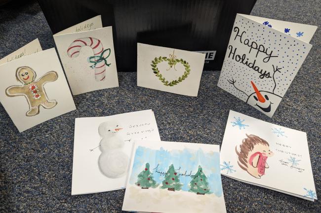 Seven holiday cards with animals, gingerbread, hearts, christmas lights, and trees.