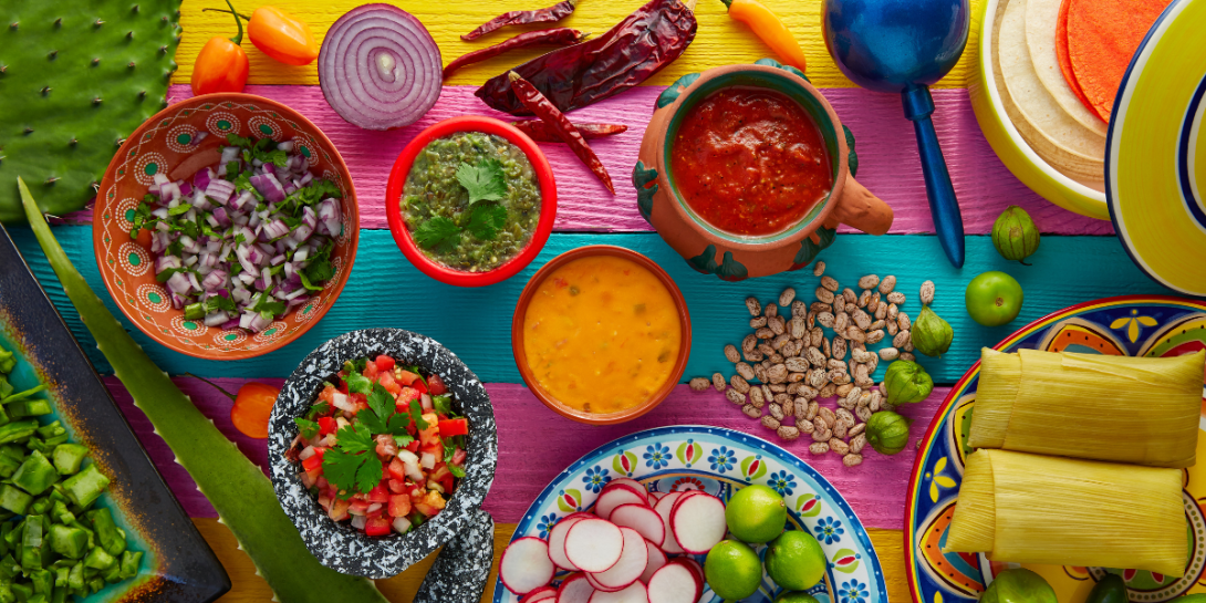 Mexican food display with sauces, nopal, tamale, agave, and guacamole