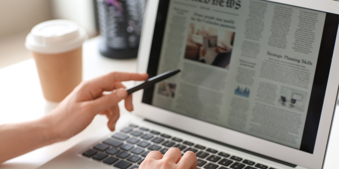 image of a person reading an online newspaper on their laptop