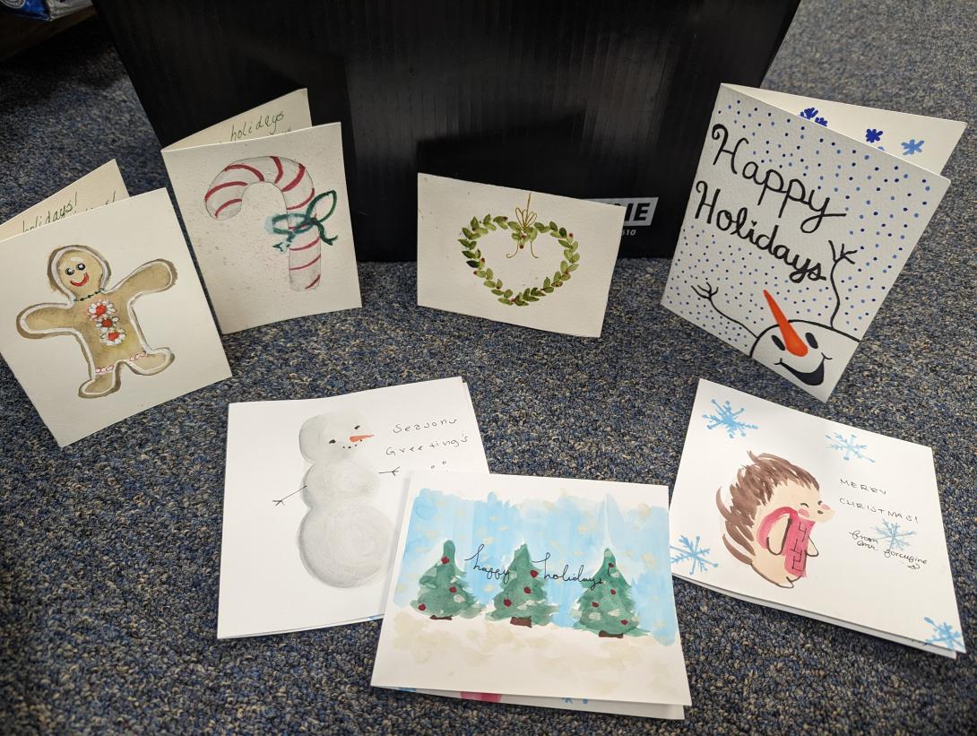 Seven holiday cards with animals, gingerbread, hearts, christmas lights, and trees.